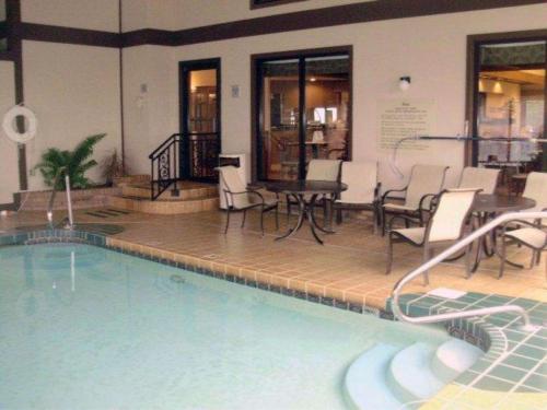 una piscina con sillas y una mesa en un edificio en Quality Inn & Suites Searcy I-67, en Searcy