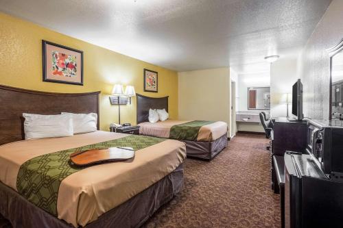 a hotel room with two beds and a flat screen tv at Econo Lodge Inn & Suites Searcy in Searcy
