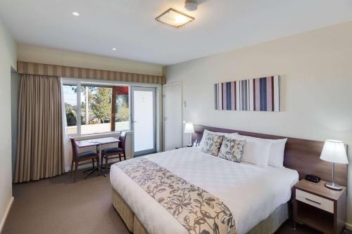 a hotel room with a large bed and a desk at Drouin Motel in Drouin