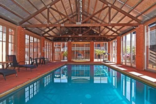 a swimming pool in a house with a large ceiling at Main Lead Ballarat Motel in Ballarat