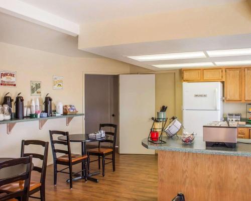 eine Küche mit einem Tisch und Stühlen sowie einem Kühlschrank in der Unterkunft Rodeway Inn Silver Creek Inn in Taylor
