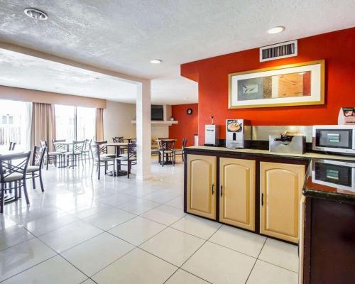 a restaurant with red walls and tables and chairs at Quality Inn Tucson Downtown near Convention Center in Tucson