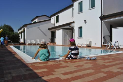 dwójka dzieci siedzących na skraju basenu w obiekcie Residence Tamerici w Caorle