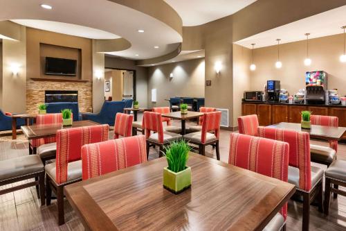 a restaurant with tables and chairs and a fireplace at Comfort Suites Goodyear-West Phoenix in Goodyear