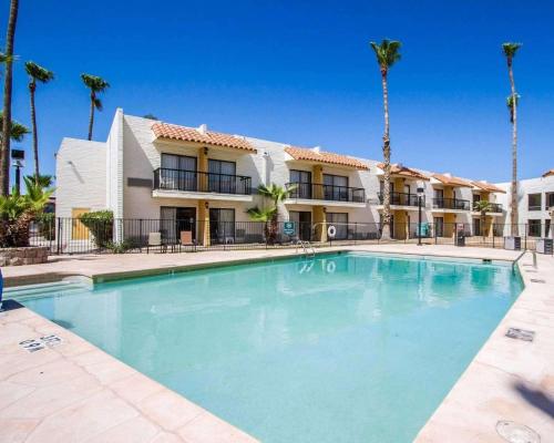 een zwembad voor een gebouw met palmbomen bij Quality Inn Tucson Downtown near Convention Center in Tucson