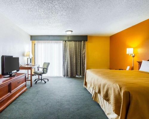 a hotel room with a bed and a desk and a television at Quality Inn Tucson Downtown near Convention Center in Tucson