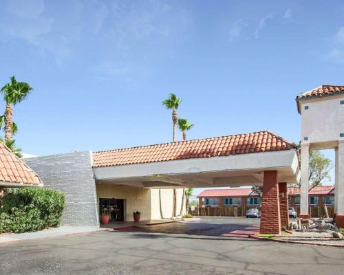 a building with a garage with palm trees at Quality Inn Tucson Downtown near Convention Center in Tucson