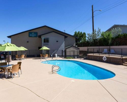 una piscina con sillas, una mesa y un edificio en Quality Inn Prescott, en Prescott