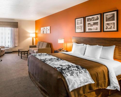 a hotel room with a large bed and a chair at Sleep Inn & Suites Page at Lake Powell in Page