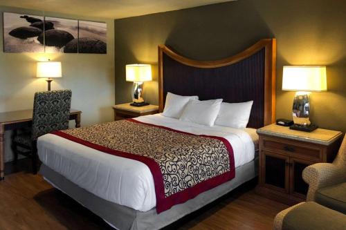 a hotel room with a large bed and two lamps at Rodeway Inn Flagstaff East Route 66 in Flagstaff