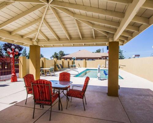 a patio with a table and chairs and a pool at Quality Inn Holbrook near Petrified Forest in Holbrook