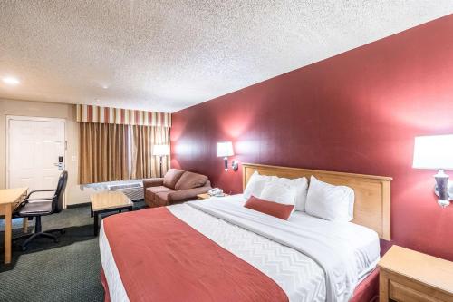 a hotel room with a large bed with a red wall at Quality Inn Casa Grande I-10 in Casa Grande