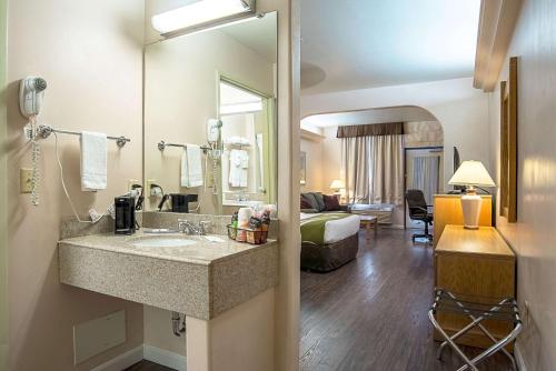 a bathroom with a sink in a hotel room at Quality Inn & Suites Phoenix NW - Sun City in Youngtown