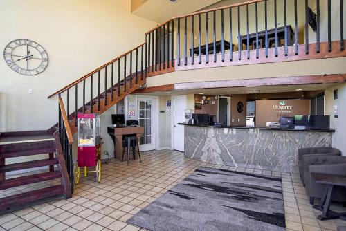 a lobby with a staircase and a counter in a store at Quality Inn & Suites Phoenix NW - Sun City in Youngtown
