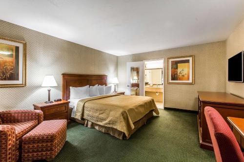 a hotel room with a bed and two chairs at Quality Inn Near China Lake Naval Station in Ridgecrest