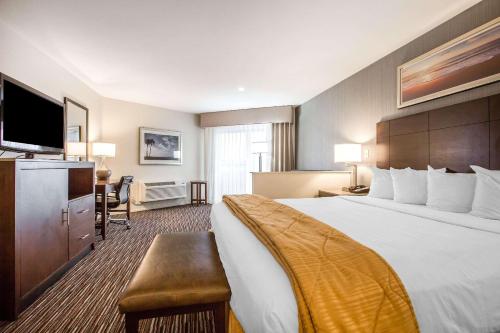 a hotel room with a large bed and a flat screen tv at Quality Inn & Suites Hermosa Beach in Hermosa Beach