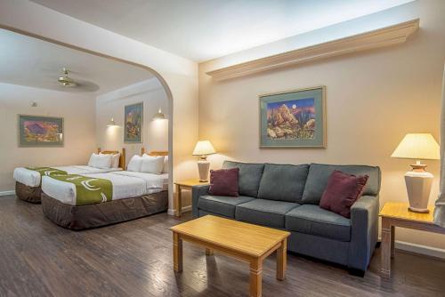 a hotel room with a bed and a couch at Quality Inn & Suites Phoenix NW - Sun City in Youngtown