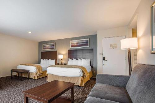 a hotel room with two beds and a couch at Quality Inn & Suites Hermosa Beach in Hermosa Beach