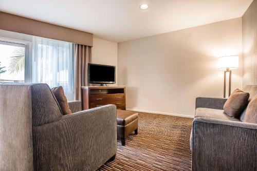 a hotel room with two chairs and a flat screen tv at Quality Inn & Suites Hermosa Beach in Hermosa Beach