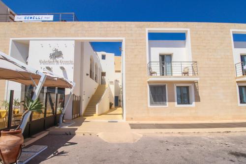 a building with two windows and a dog on the outside at Hotel Paladini di Francia in Lampedusa