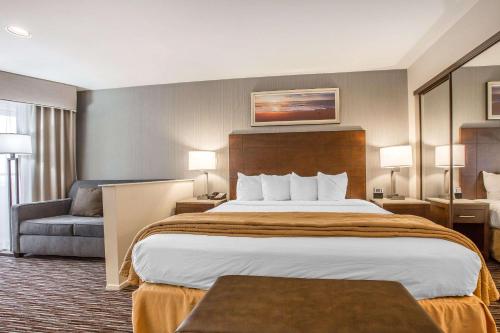 a hotel room with a large bed and a chair at Quality Inn & Suites Hermosa Beach in Hermosa Beach