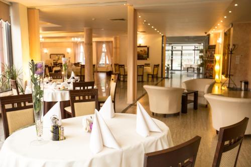 a restaurant with tables and chairs with white table cloth at Hotel Monet & Rubbens in Toruń