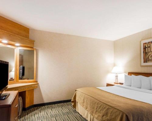 a hotel room with a bed and a flat screen tv at Quality Inn Petaluma - Sonoma in Petaluma