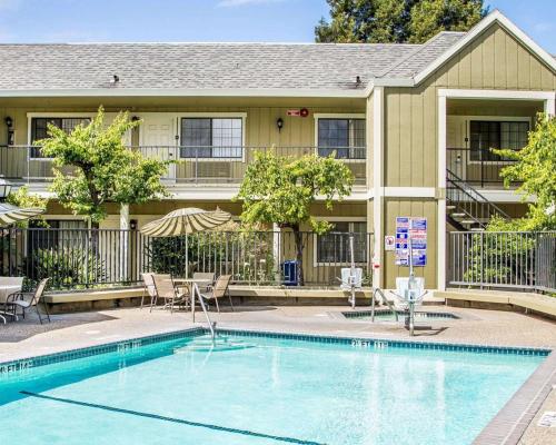 a swimming pool in front of a building with a house at Quality Inn Petaluma - Sonoma in Petaluma
