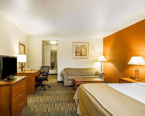 a hotel room with a bedroom with a bed and a desk at Quality Inn Petaluma - Sonoma in Petaluma