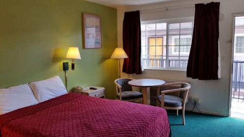 um quarto de hotel com uma cama e uma mesa com cadeiras em Rodeway Inn Civic Center em São Francisco