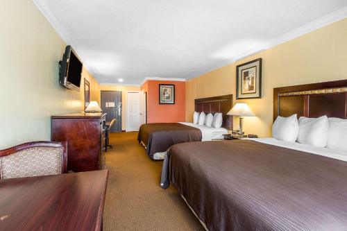 a hotel room with two beds and a tv at Quality Inn & Suites Bell Gardens-Los Angeles in Bell Gardens