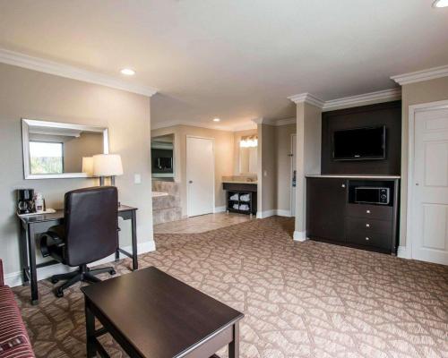 a living room with a couch and a desk and a television at Comfort Suites San Clemente Beach in San Clemente