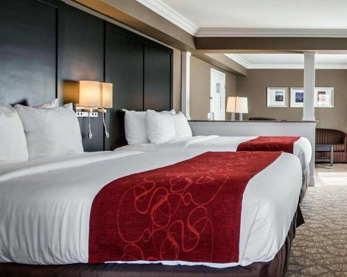 a hotel room with a large bed with a red blanket at Comfort Suites San Clemente Beach in San Clemente