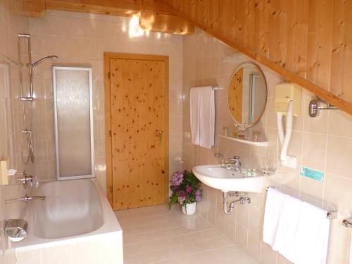 W łazience znajduje się wanna, umywalka i prysznic. w obiekcie Hotel Fortuna w mieście Ortisei