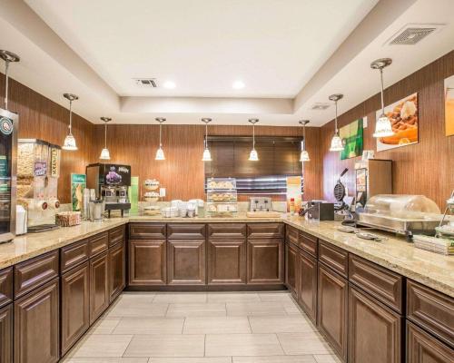 a large kitchen with wooden cabinets and counters at Quality Inn & Suites Woodland - Sacramento Airport in Woodland