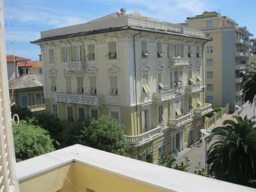 a large white building with balconies and trees at Hotel Miramare in Lavagna