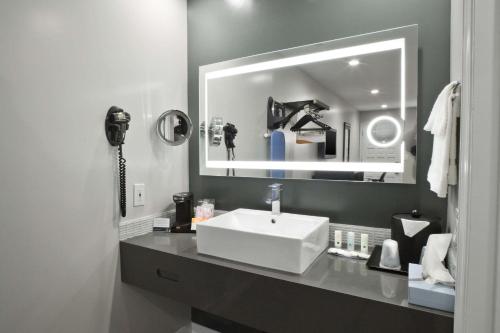 a bathroom with a white sink and a mirror at Bay Area Inn & Suites in Hayward