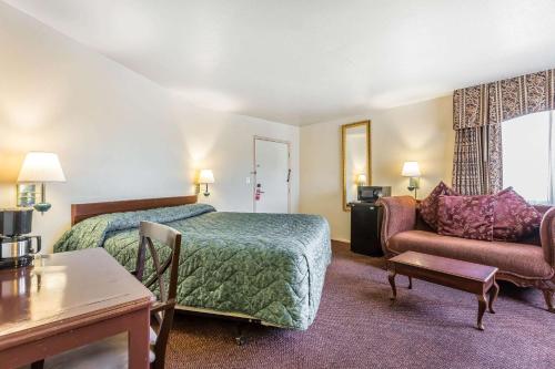 a hotel room with a bed and a couch at Rodeway Inn Magic Mountain Area in Castaic
