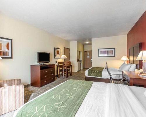 a hotel room with a bed and a desk and a television at Comfort Suites Palm Desert I-10 in Palm Desert
