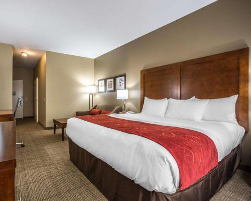 a hotel room with a large bed with a red blanket at Comfort Suites Victorville-Hesperia in Victorville
