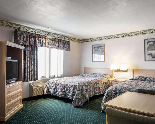 Cette chambre comprend deux lits et une télévision. dans l'établissement Rodeway Inn Monterey Near Fairgrounds, à Monterey