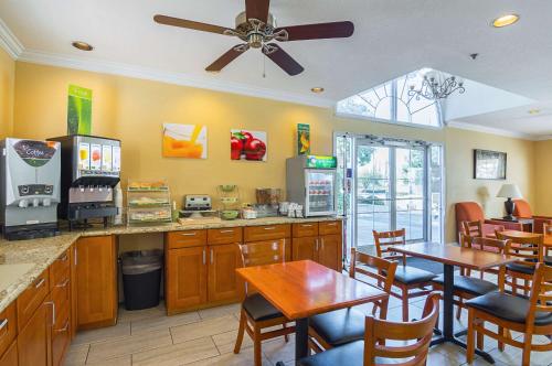a restaurant with a table and chairs and a kitchen at Quality Inn Fresno Yosemite Airport in Fresno