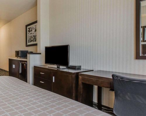 a hotel room with a bed and a desk with a television at Quality Inn Rosemead-Los Angeles in Rosemead
