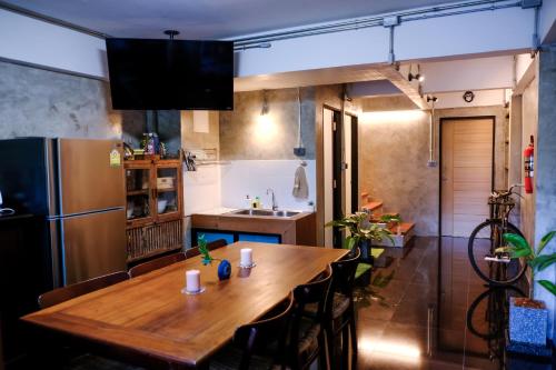 a kitchen with a wooden table and a refrigerator at Baan Lung Poshtel in Chiang Mai