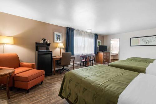 a hotel room with two beds and a desk at BaySide Inn & Suites Eureka in Eureka