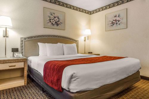 a hotel room with a large bed with a red blanket at Comfort Inn Palo Alto in Palo Alto