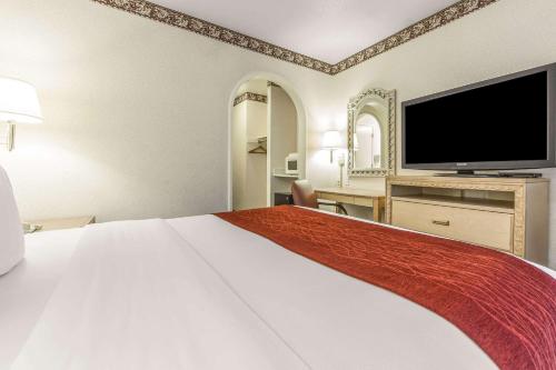 a hotel room with a large bed and a flat screen tv at Comfort Inn Palo Alto in Palo Alto