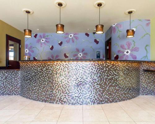 a bathroom with a tile counter and a mirror at Villa Montes Hotel in San Bruno