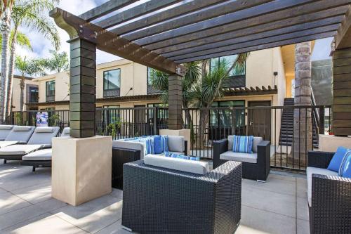 a patio with lounge chairs and a pergola at The Cove Hotel in Long Beach