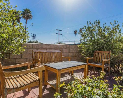 three wooden benches and a table and a wall at Quality Inn Rosemead-Los Angeles in Rosemead